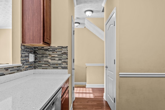 kitchen with dark hardwood / wood-style flooring, light stone countertops, a textured ceiling, and decorative backsplash