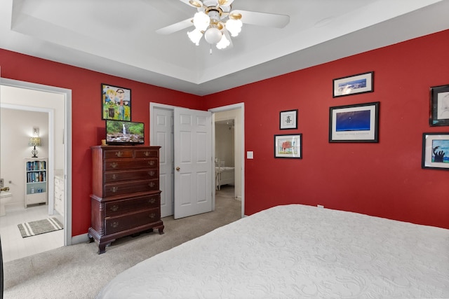 1027 Harper St, Madison, GA 30650 - bedroom featuring carpet flooring, a tray ceiling, connected bathroom, and ceiling fan