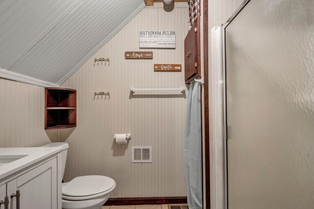 bathroom featuring vanity, vaulted ceiling, toilet, and walk in shower