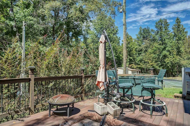 deck with a shed and a fire pit