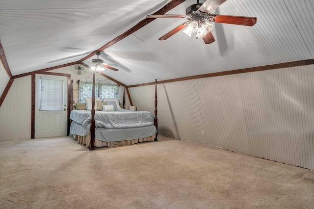 unfurnished bedroom featuring light carpet, vaulted ceiling with beams, and ceiling fan