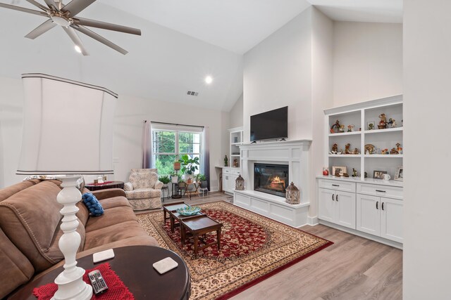 165 Hunters Chase Ct, Eatonton, GA 31024 - living room featuring light wood-style flooring, high vaulted ceiling, a ceiling fan, a glass covered fireplace, and recessed lighting