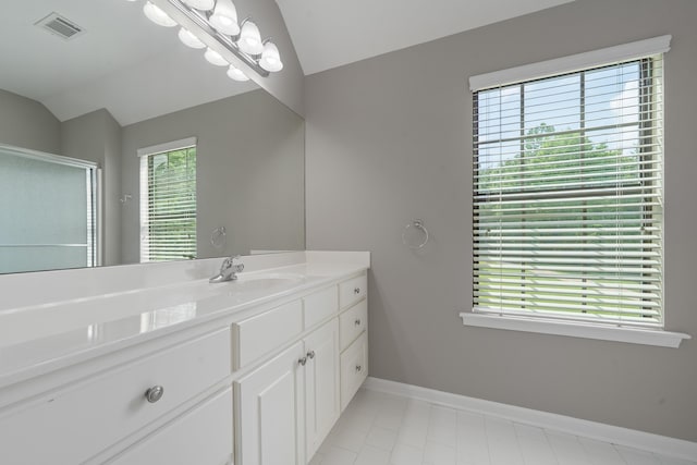 32 Lily Pt, Sparta, GA 31087 - bathroom featuring vaulted ceiling, vanity, healthy amount of natural light, a shower stall, and baseboards
