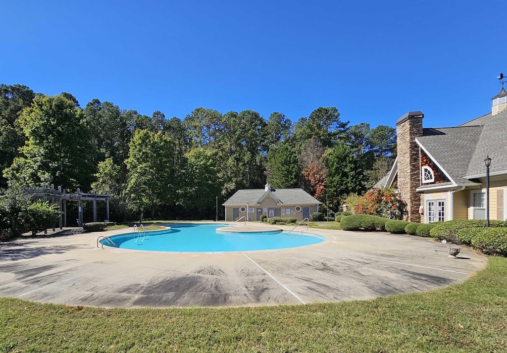 view of swimming pool featuring a patio, a lawn, and a pergola