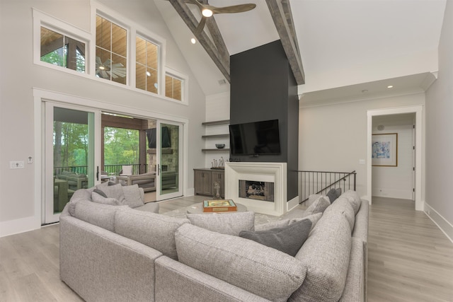 living room featuring beamed ceiling, ceiling fan, high vaulted ceiling, and light wood-type flooring