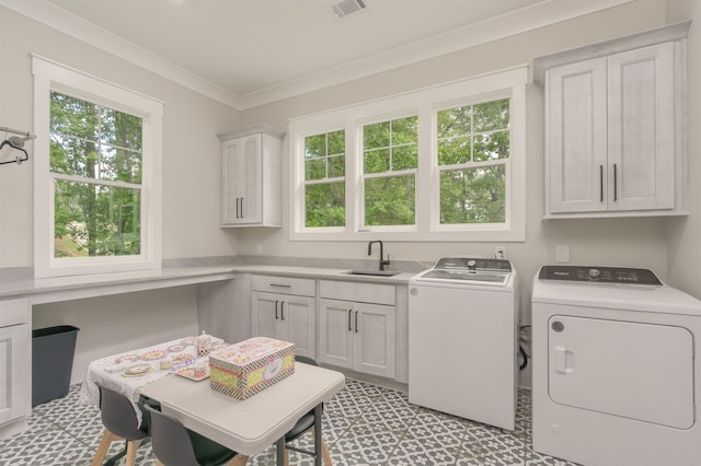 laundry area with sink, washer and clothes dryer, ornamental molding, and cabinets