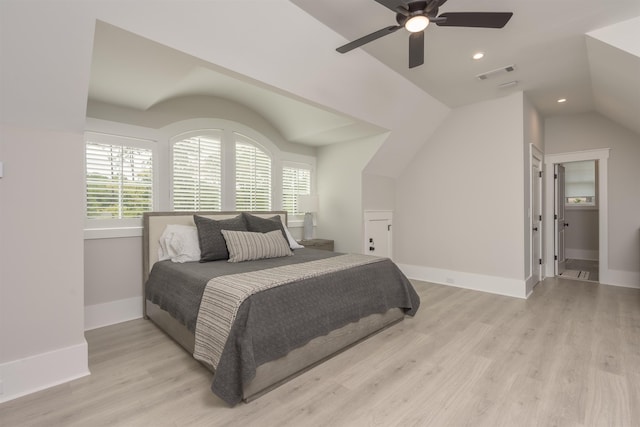 bedroom with ceiling fan, vaulted ceiling, and light wood-type flooring