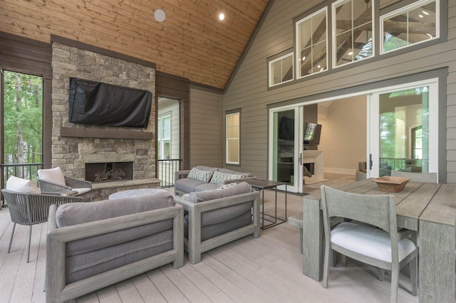 interior space with light hardwood / wood-style flooring, an outdoor stone fireplace, and wood walls