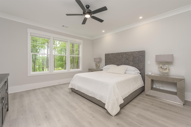 bedroom with light hardwood / wood-style flooring, ornamental molding, and ceiling fan