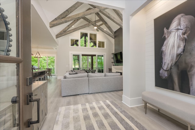 living room featuring beam ceiling, light hardwood / wood-style flooring, and high vaulted ceiling