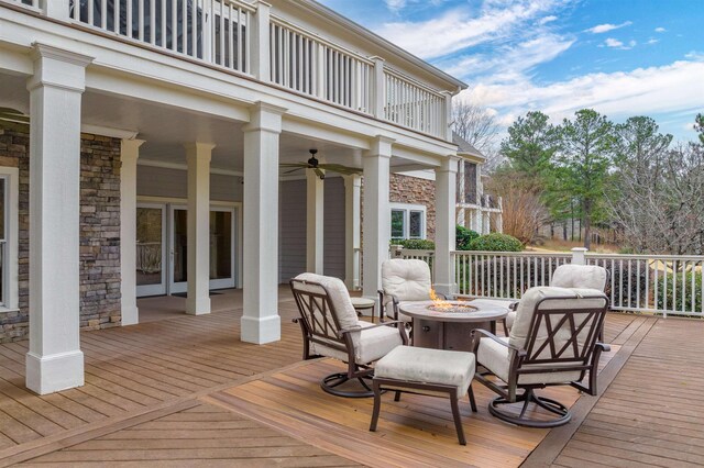 wooden deck featuring ceiling fan and an outdoor fire pit