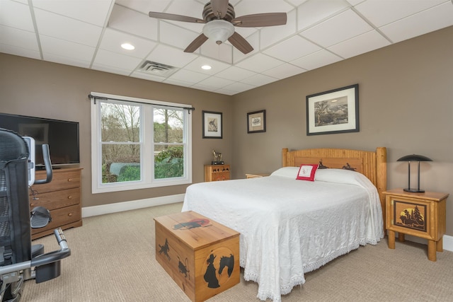 carpeted bedroom featuring ceiling fan and a paneled ceiling