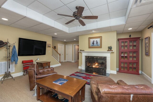 carpeted living room featuring a drop ceiling and ceiling fan