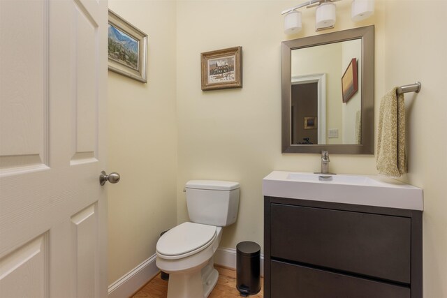 bathroom featuring hardwood / wood-style flooring, vanity, and toilet