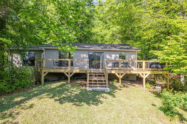 rear view of property with a deck and a yard