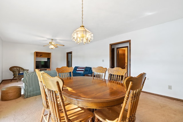 184 Crooked Creek Bay Rd, Eatonton, GA 31024 - dining room featuring light colored carpet, a chandelier, a ceiling fan, and baseboards