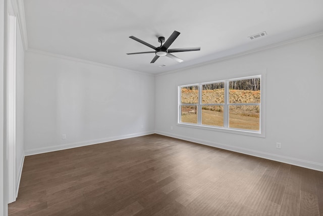 spare room featuring dark wood finished floors, baseboards, visible vents, and ornamental molding