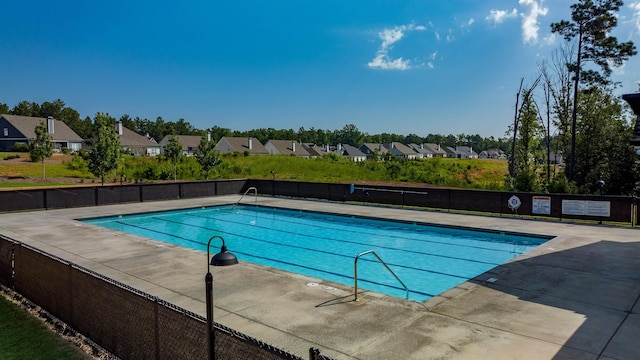 pool featuring a residential view, a patio, and fence