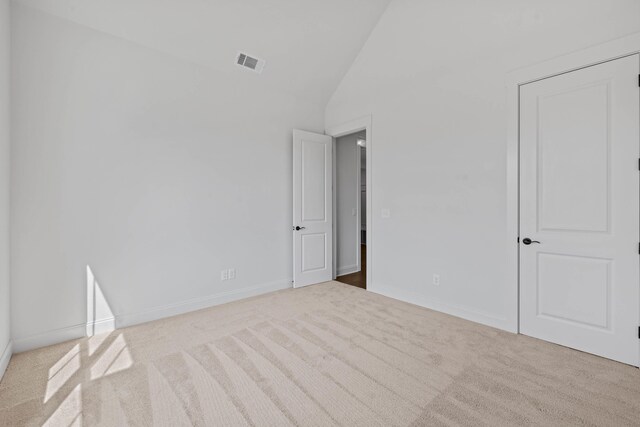 unfurnished bedroom featuring visible vents, carpet floors, high vaulted ceiling, and baseboards