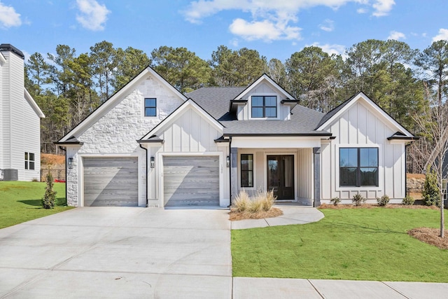 modern farmhouse with a front yard, a garage, board and batten siding, and driveway