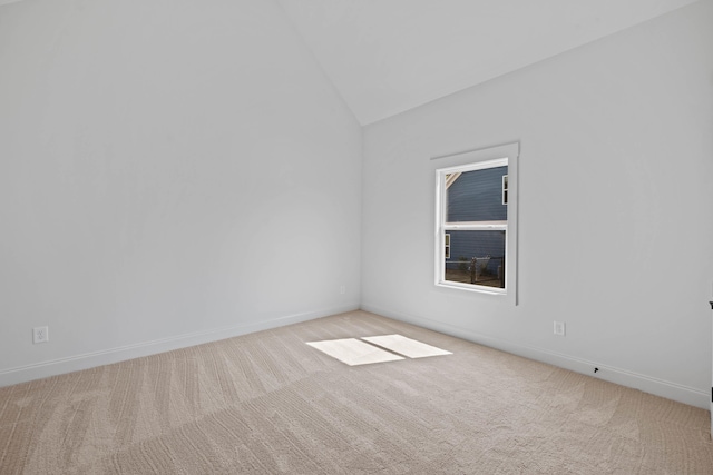 spare room featuring vaulted ceiling, baseboards, and carpet floors