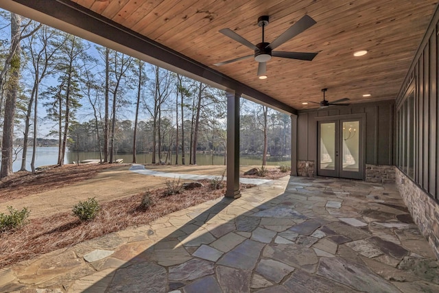 view of patio with a water view, ceiling fan, and french doors