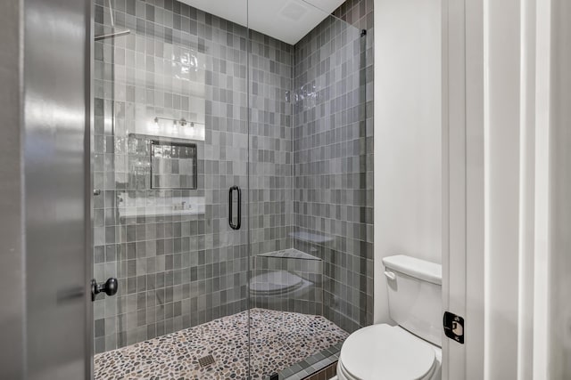 bathroom with an enclosed shower and toilet