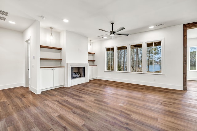 unfurnished living room with ceiling fan and dark hardwood / wood-style flooring