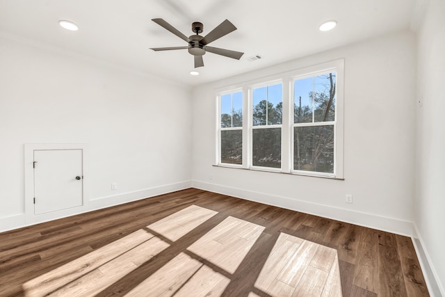 spare room featuring dark wood-type flooring and ceiling fan