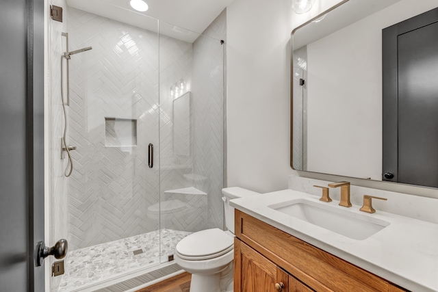 bathroom with vanity, toilet, and a shower with door