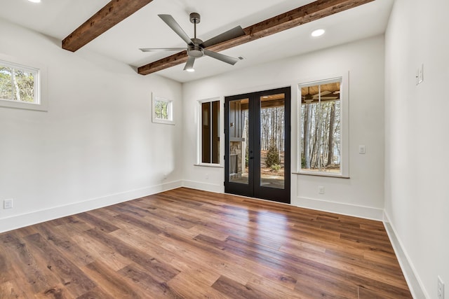 spare room featuring wood-type flooring, ceiling fan, beam ceiling, and french doors