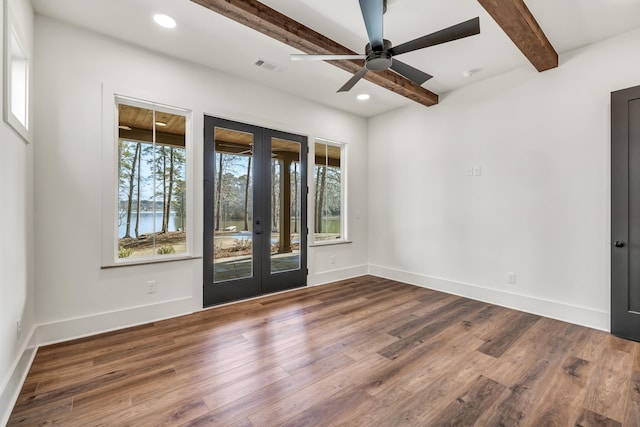 empty room featuring hardwood / wood-style flooring, a water view, a wealth of natural light, french doors, and beamed ceiling