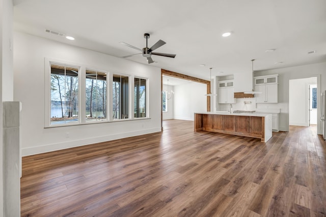 unfurnished living room featuring dark hardwood / wood-style flooring and ceiling fan