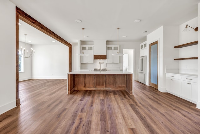 kitchen with white cabinetry, dark hardwood / wood-style floors, high end refrigerator, and decorative light fixtures