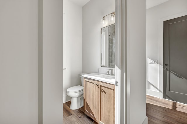 bathroom with vanity, toilet, and wood-type flooring