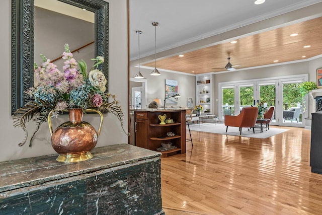 interior space featuring hardwood / wood-style floors, crown molding, wooden ceiling, and ceiling fan