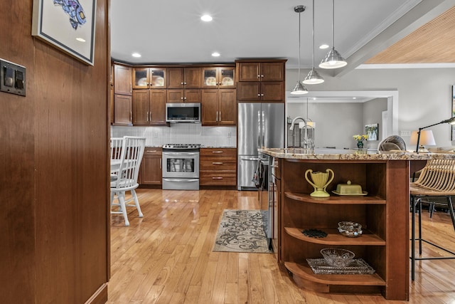 kitchen featuring open shelves, a kitchen breakfast bar, tasteful backsplash, stainless steel appliances, and light wood finished floors