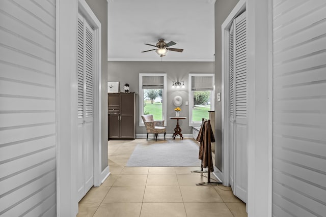 hallway featuring ornamental molding and light tile patterned floors