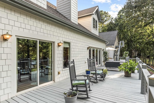 wooden terrace with an outdoor living space