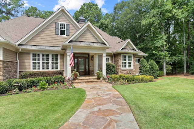 1191 Linger Longer Dr, Greensboro, GA 30642 - craftsman house featuring stone siding, a standing seam roof, a front yard, and a shingled roof