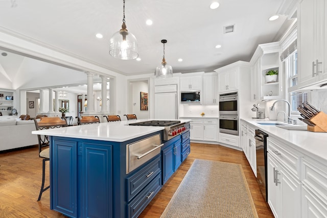 1191 Linger Longer Dr, Greensboro, GA 30642 - kitchen featuring blue cabinets, a warming drawer, stainless steel appliances, a kitchen breakfast bar, and white cabinetry