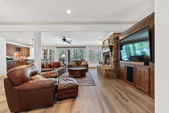 1191 Linger Longer Dr, Greensboro, GA 30642 - living area featuring light wood finished floors, a ceiling fan, recessed lighting, a stone fireplace, and ornamental molding