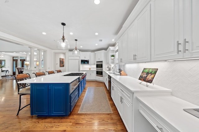 1191 Linger Longer Dr, Greensboro, GA 30642 - kitchen with blue cabinetry, white cabinetry, a kitchen breakfast bar, light countertops, and decorative backsplash