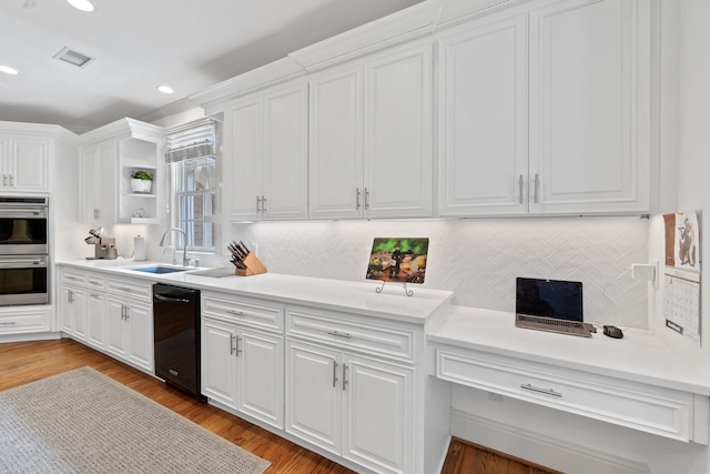 1191 Linger Longer Dr, Greensboro, GA 30642 - kitchen with black dishwasher, stainless steel double oven, white cabinetry, recessed lighting, and backsplash