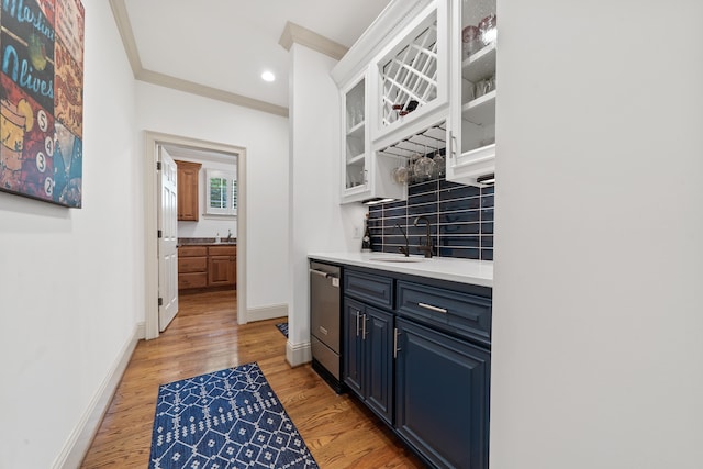 1191 Linger Longer Dr, Greensboro, GA 30642 - indoor wet bar featuring decorative backsplash, light wood-style floors, stainless steel dishwasher, ornamental molding, and recessed lighting