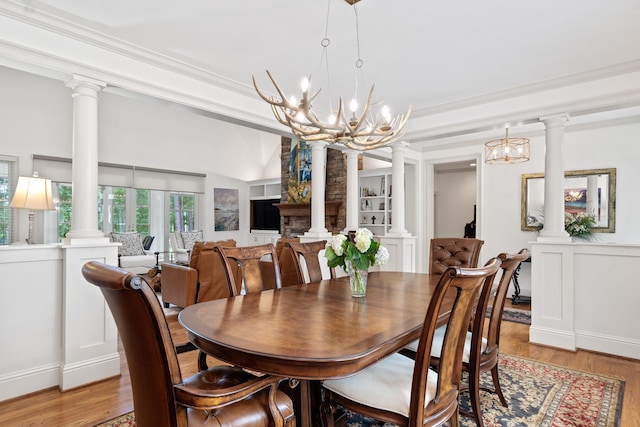 1191 Linger Longer Dr, Greensboro, GA 30642 - dining space featuring decorative columns, light wood-type flooring, a chandelier, and crown molding