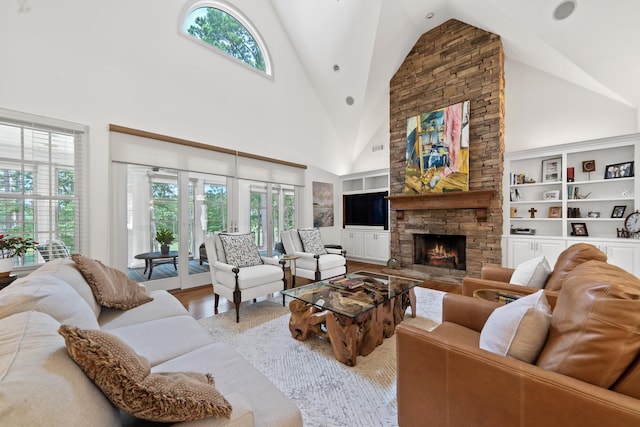 1191 Linger Longer Dr, Greensboro, GA 30642 - living area with plenty of natural light, high vaulted ceiling, built in shelves, a fireplace, and wood finished floors