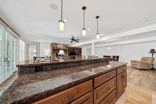 1191 Linger Longer Dr, Greensboro, GA 30642 - kitchen featuring open floor plan, light wood finished floors, a ceiling fan, brown cabinetry, and recessed lighting