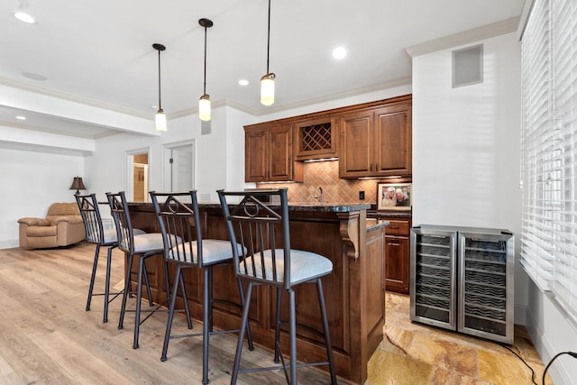 1191 Linger Longer Dr, Greensboro, GA 30642 - kitchen featuring wine cooler, a kitchen breakfast bar, tasteful backsplash, crown molding, and a center island