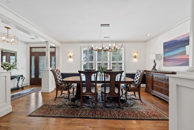 1191 Linger Longer Dr, Greensboro, GA 30642 - dining space featuring a chandelier, ornamental molding, decorative columns, and wood finished floors